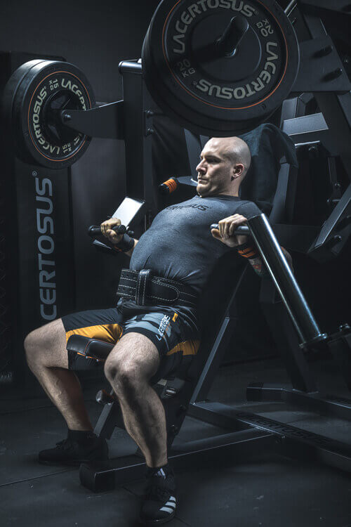 Hombre realizando ejercicios en una máquina de pectorales en el gimnasio.