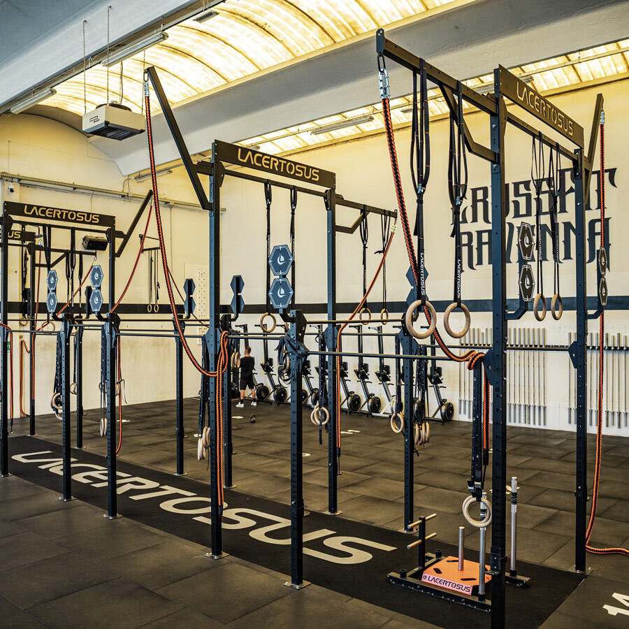 Gimnasio de entrenamiento con equipamiento de levantamiento de pesas y anillas.
