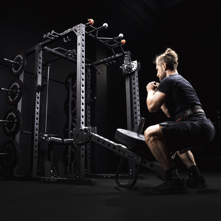 Hombre realizando ejercicio en el gimnasio con equipo de levantamiento de pesas.