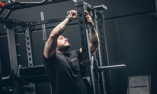Hombre entrenando con una máquina de dominadas en el gimnasio.